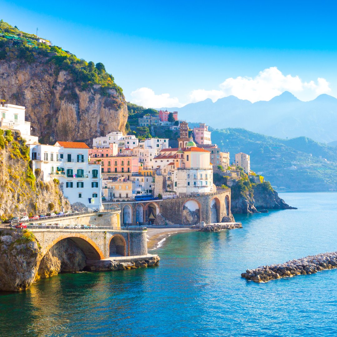 Il borgo di pescatori di Atrani visto dal mare, con il campanile e le case pastello incastrate tra scogliera e spiaggia, Costiera Amalfitana